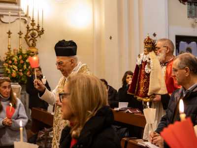 ...che avanza in chiesa seguito da una fila di preti e canonici